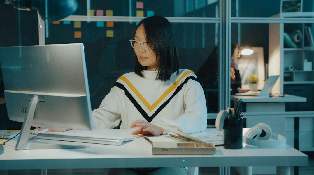 Swiss woman reading a printed advertising archive folder in a bright office